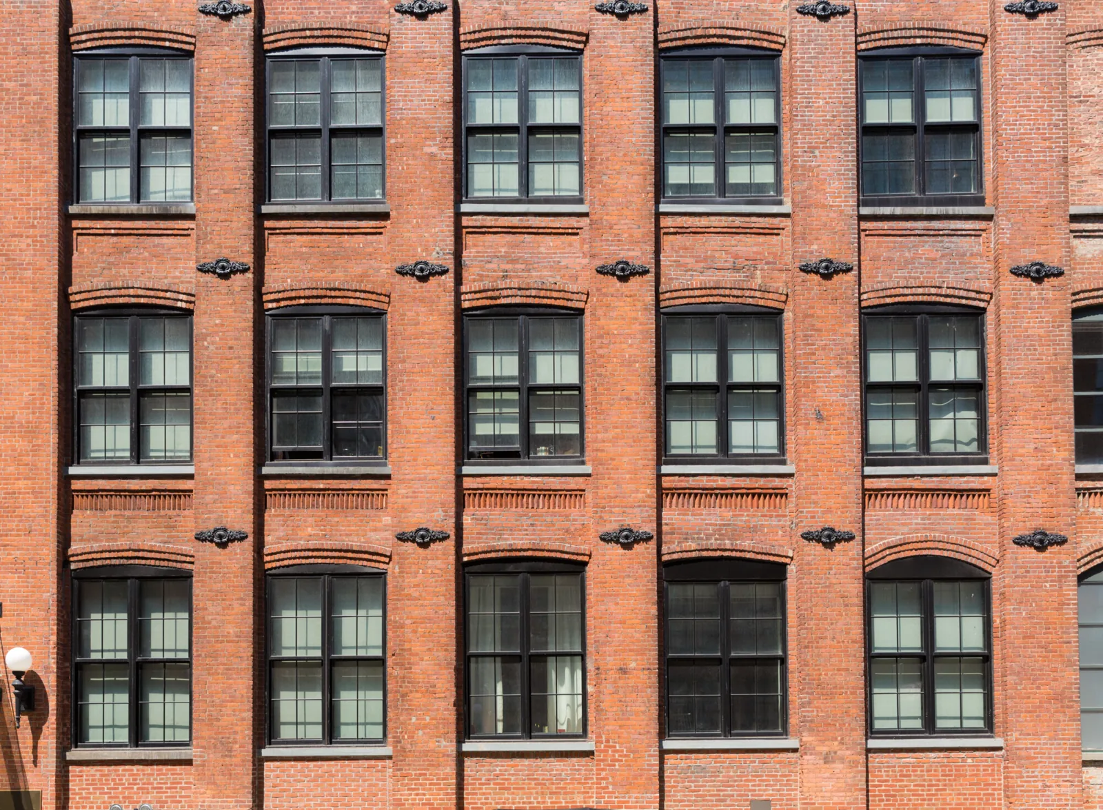 Red brick multifamily building with rows of windows